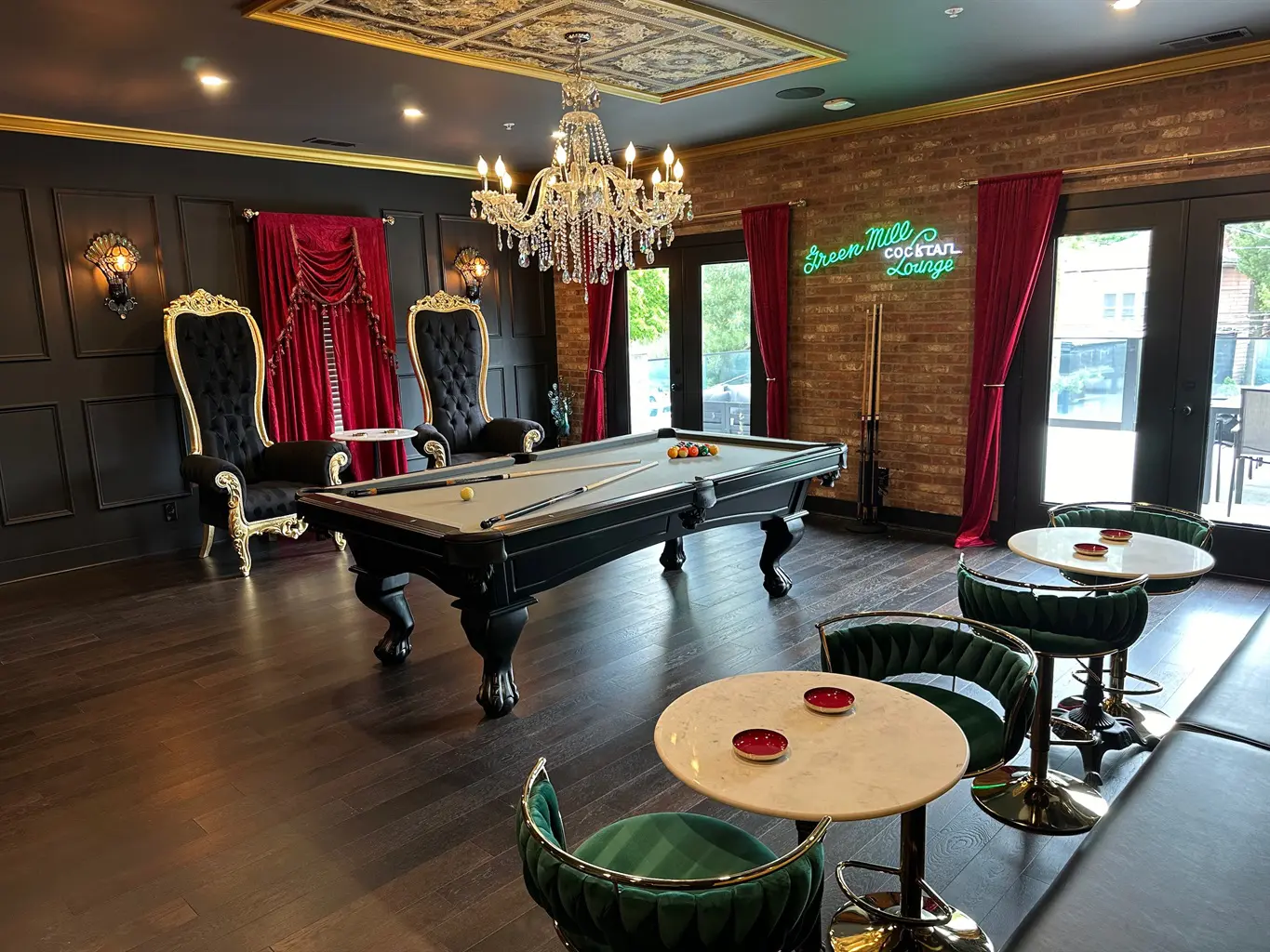 A room with a pool table and chairs