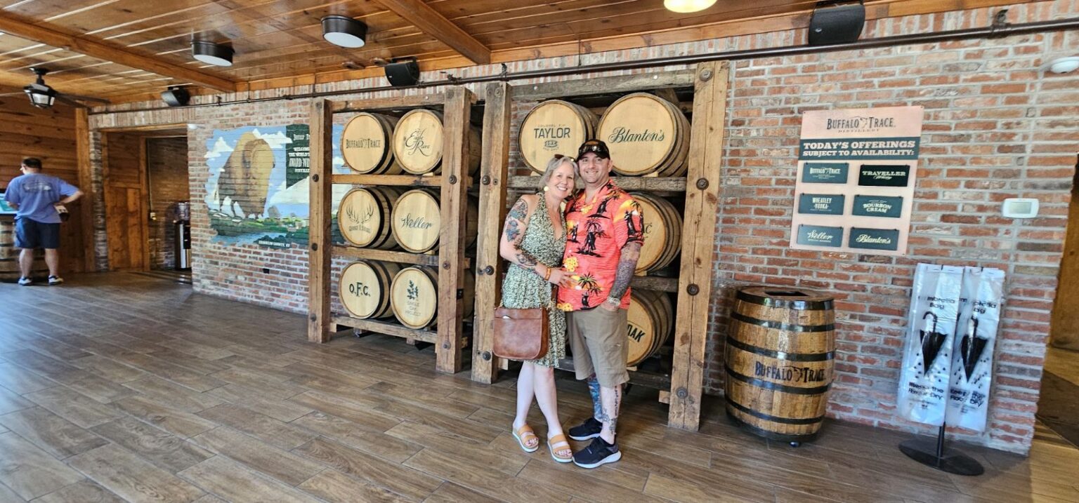 A man and woman standing in front of barrels.