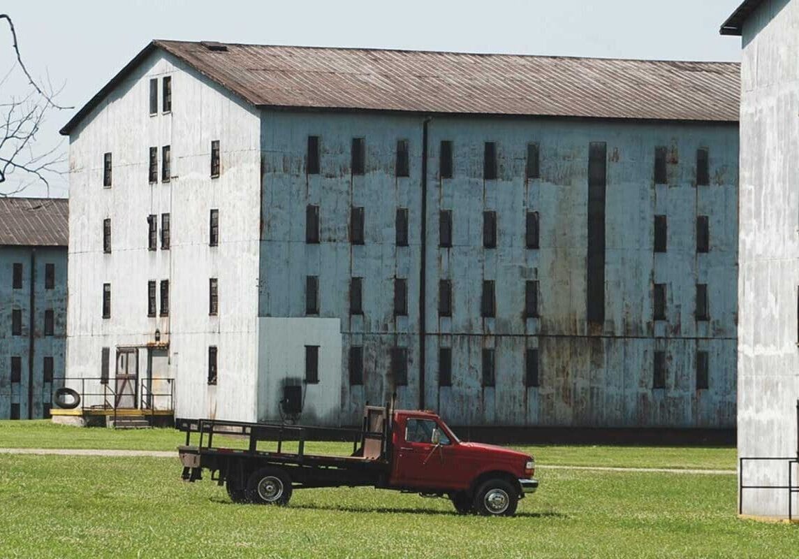 A red truck parked in front of an old building.