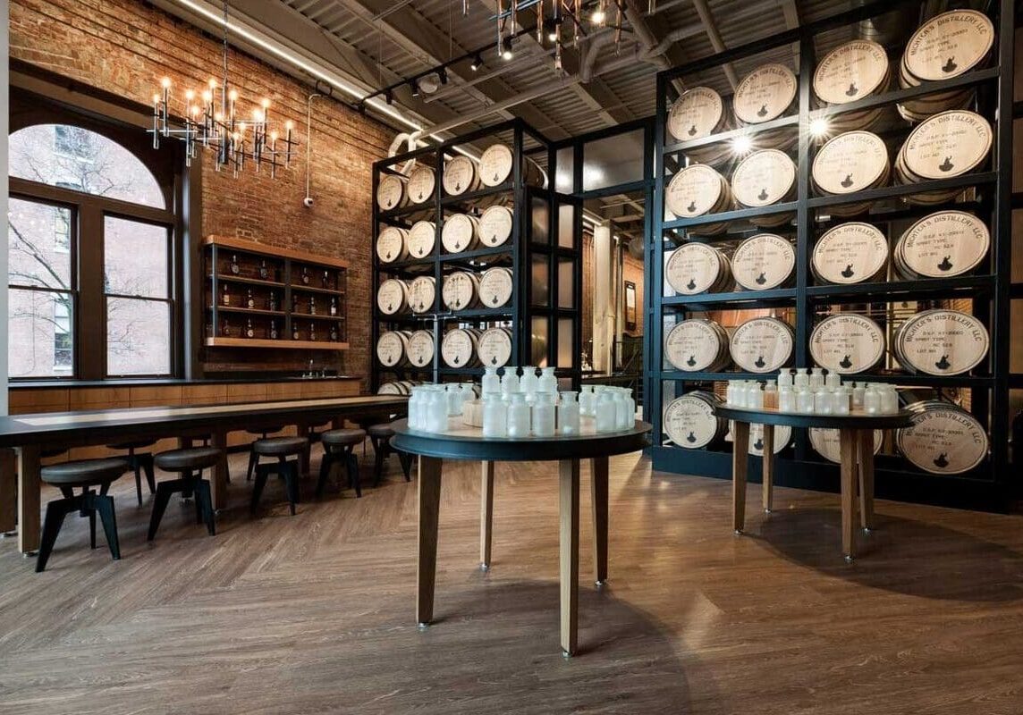 A room filled with tables and chairs next to barrels.